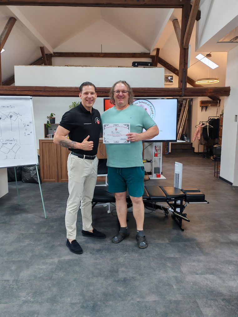 Maroš Kellner preberá certifikát Whole Body Chiropractic: Advanced Level od lektora menom Kamil Rządkowski